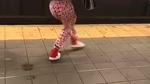 731am girl dancing on subway platform red pants