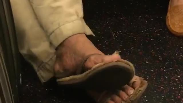 Zooming in on a mans toe nails on subway train