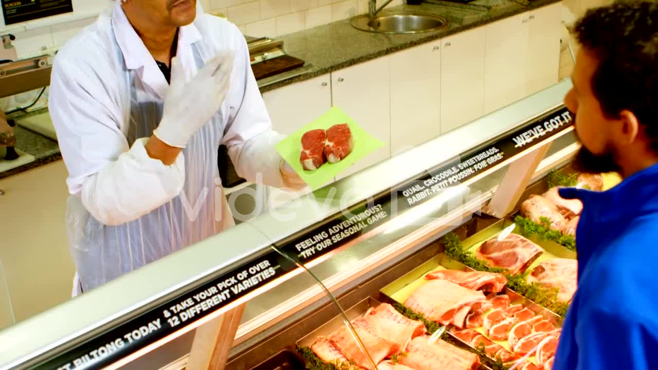 Butcher selling meat to customer at shop 4k