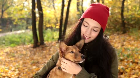 Woman with her little dog looking at the camera