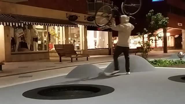 Guy carrying bike over head falls