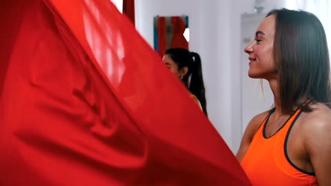 Women shaking cloth for aerial yoga