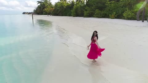 Woman spins in a circle at the beach