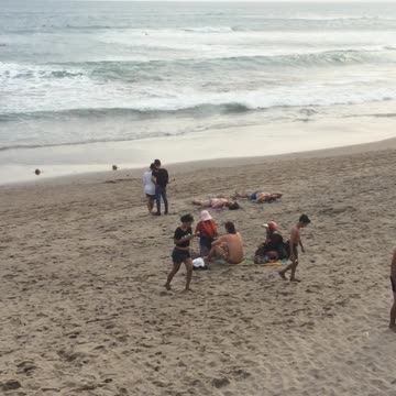 Guy walking on beach with motorcycle helmet on