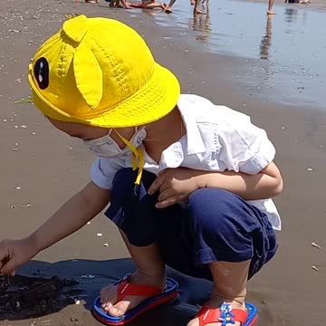 Baby playing sand in the sea