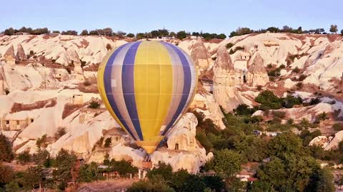 Yellow Air Balloon flying over a beautiful landscape.