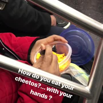 Woman eats cheetos with fork on subway train
