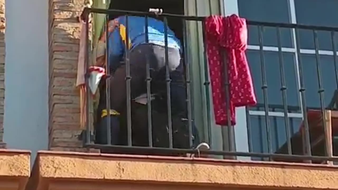 Man climbs a building to help an elderly woman who fell