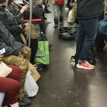 Man in red shirt claps and walks thru subway