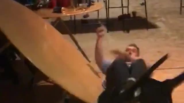 Blue shirt elbow drops wooden circle table