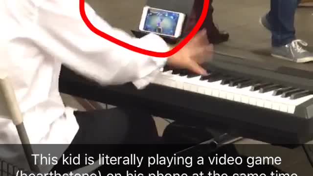 Kid white dress shirt playing piano in subway while playing hearthstone game on phone