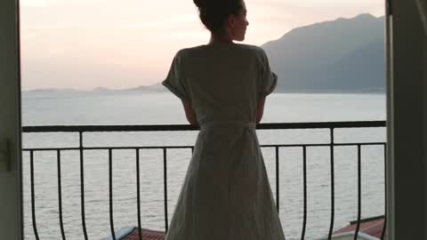 Woman looking at the view of the sea from balcony