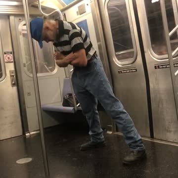 Guy black grey striped shirt head on pole balance