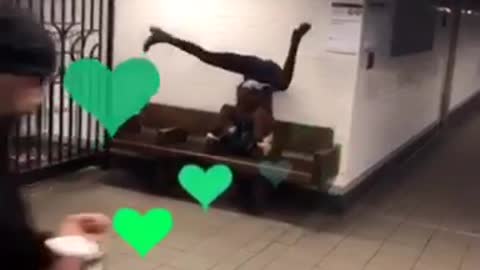 Person does handstand on subway platform bench