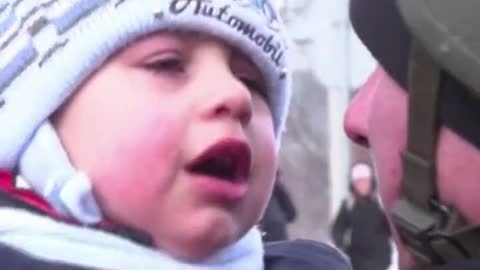 A Ukrainian baby sobs and puts up a fight as his father tries to hug him and say goodbye.