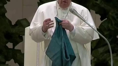 Pope Francis holds up battered Ukrainian flag sent from Bucha and kisses it.