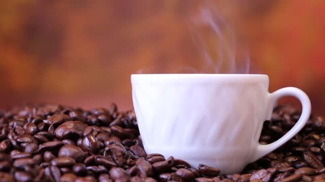 Cup Of Coffee On Top Of Coffee Beans .