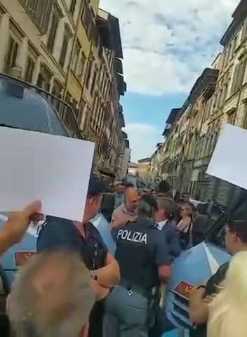 Cops in Italy are surrounded by their elders holding up pictures of vaccine victims