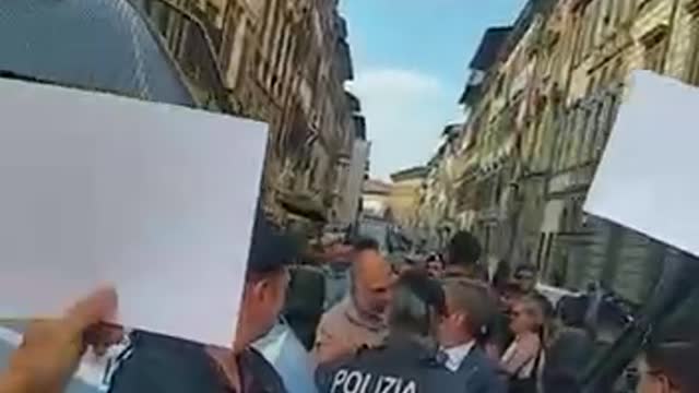 Cops in Italy are surrounded by their elders holding up pictures of vaccine victims