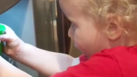 funny baby runs water from fridge