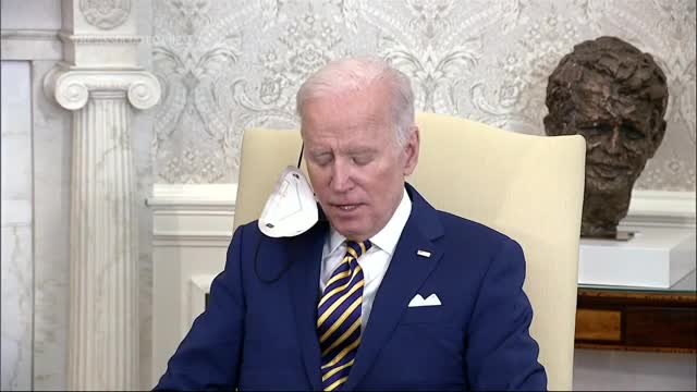 Biden threatens war with Russia, while a face diaper hangs from his ear....