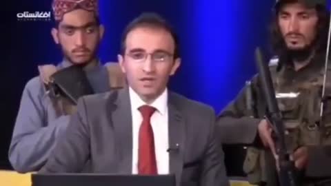 Armed Taliban terrorists stand behind TV presenter as he reads their propaganda messages