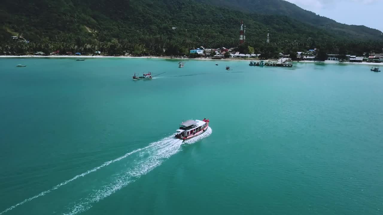 Beautiful coast with motorboats and a pier seen from the air