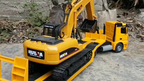 RC Excavator getting off yellow trailer truck