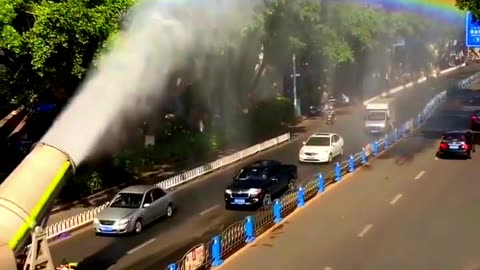 A truck Creates a beautiful rainbow while cleaning the streets.