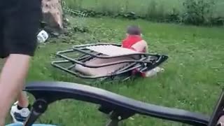 Rowdy Toddler Cradled by Folding Chair