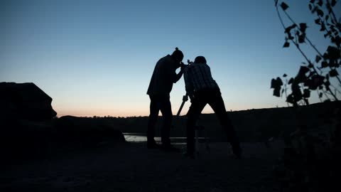 A couple of friends stargazing using the telescope