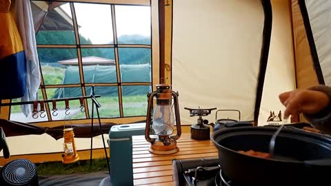 A family with three people camping in the rain