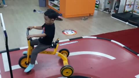 Handsome Boy Playing Tricycle at Playground