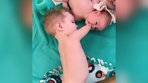 Little boy gives baby brother pacifier