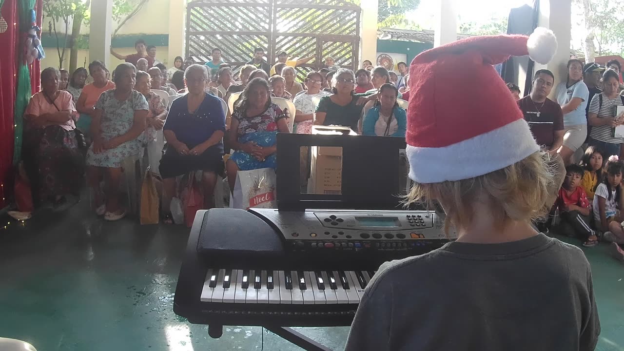 Elan plays piano for X-mas crowd in Olon, Ecuador