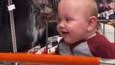 Baby laughs at scary mask by mom.