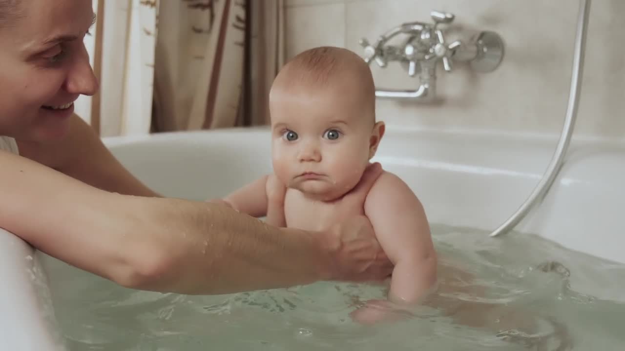 Mother playing with her baby in a tub of water