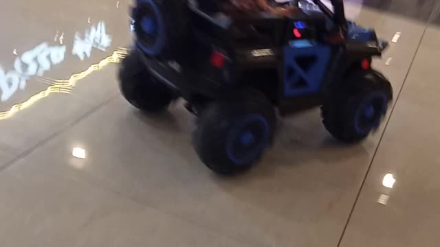 Baby boy a riding a car in shopping mall