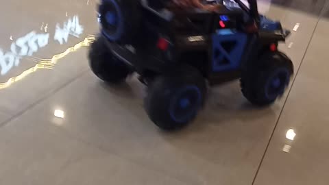 Baby boy a riding a car in shopping mall