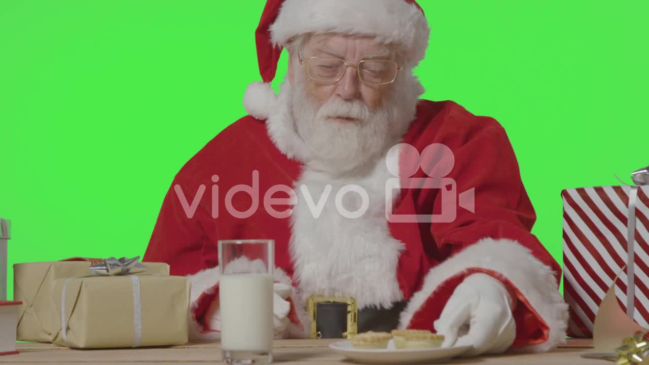 Portrait Shot of Santa Pulling a Plate of Mince Pies to Him