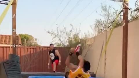 Guy Falls on Mattress While Hanging From Horizontal Bar and Performing Trick