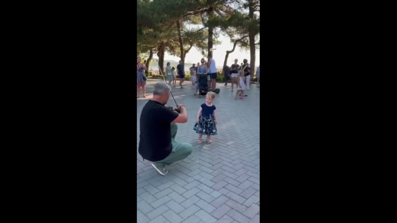 Little girl totally amazed by live violin performance