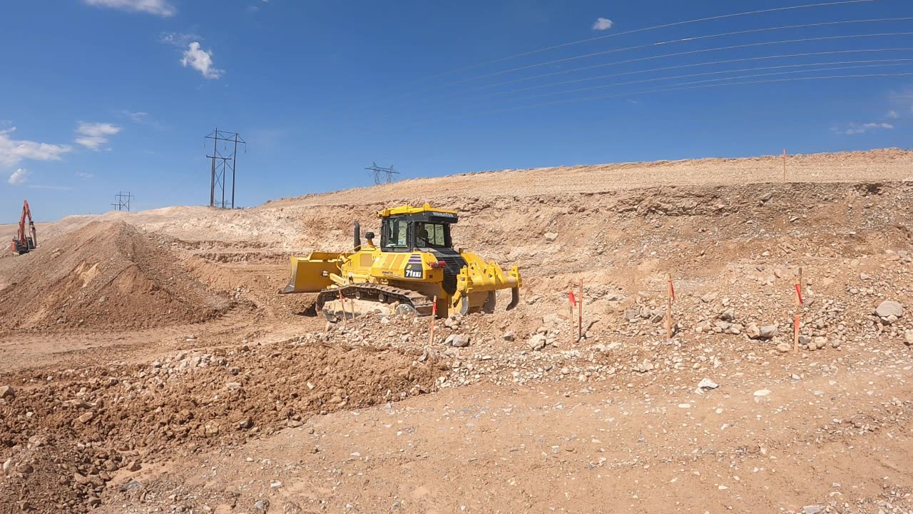 Cutting retaining wall footing with a Komatsu D71 with reverse grading.