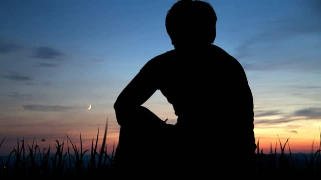 A sading Man in sunset and birds flying over him so emotional