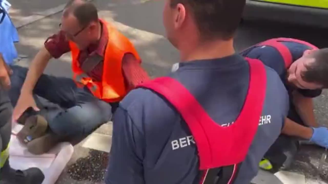 German Eco-activist screams as emergency service workers try remove his glued hand from the road.