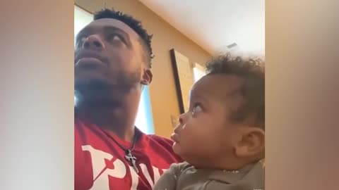 Baby boy stared at his father when he was secretly kissed on the head