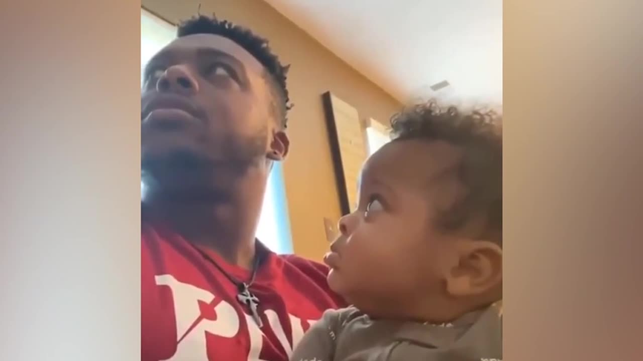 Baby boy stared at his father when he was secretly kissed on the head