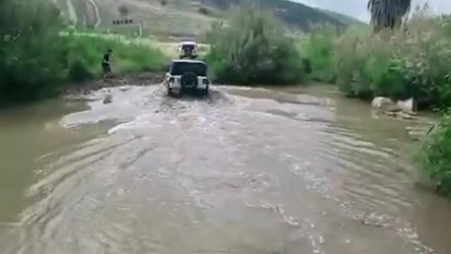 Black top Jeep across the shallows
