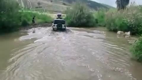 Black top Jeep across the shallows