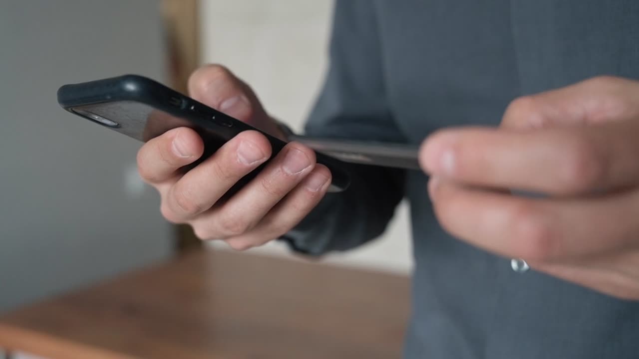 A man using smartphone while holding a credit card!